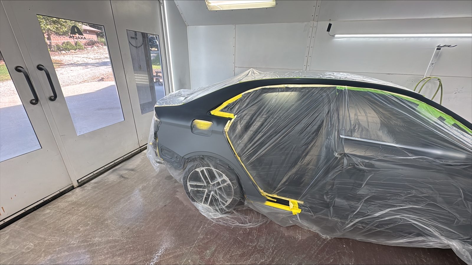 Black Audi masked for refinishing in the paint area